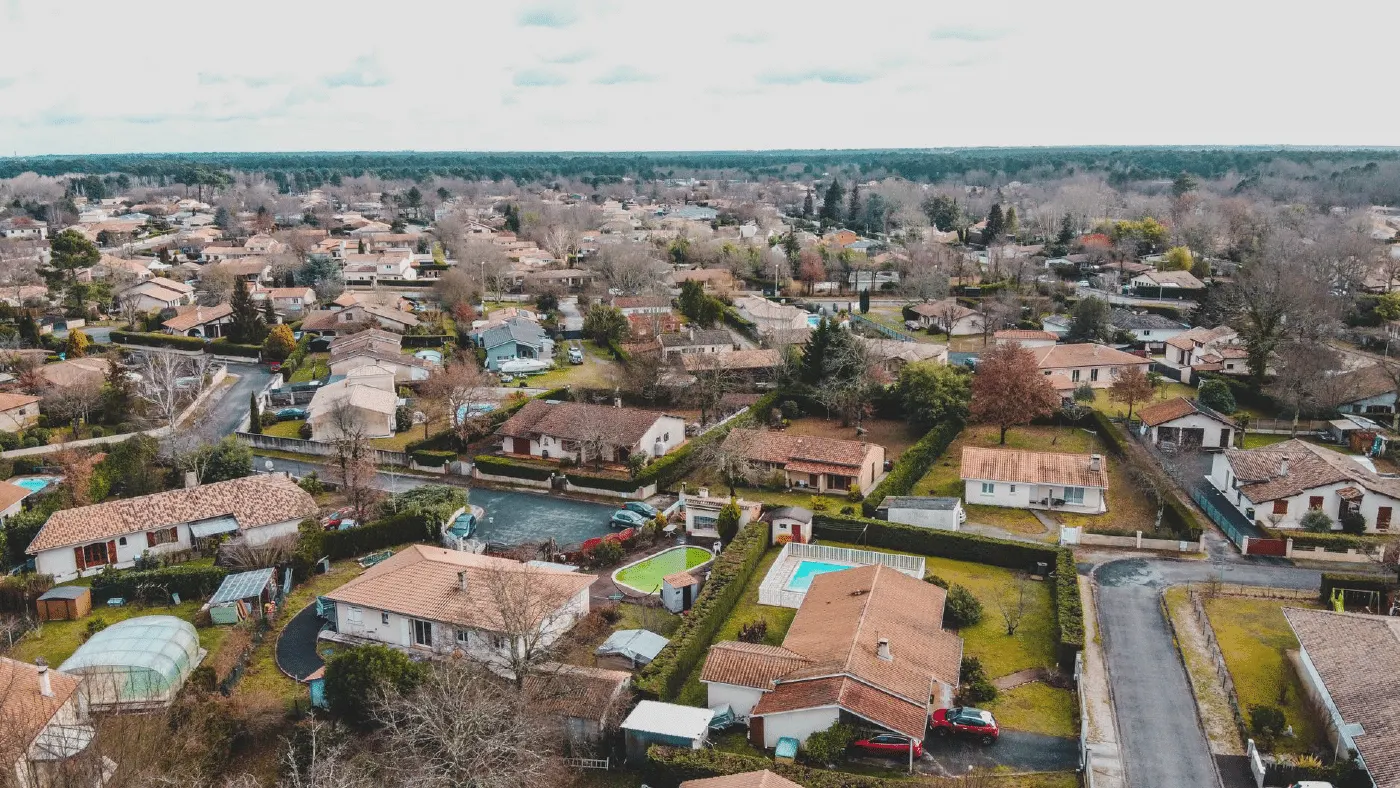 Vue aérienne d'un quartier résidentiel de maisons en France, le type de secteur qu'une page quartier d'agence immobilière décrit