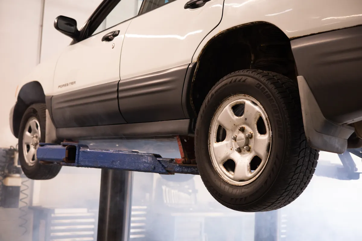 Voiture levée sur un pont élévateur dans un atelier de réparation automobile