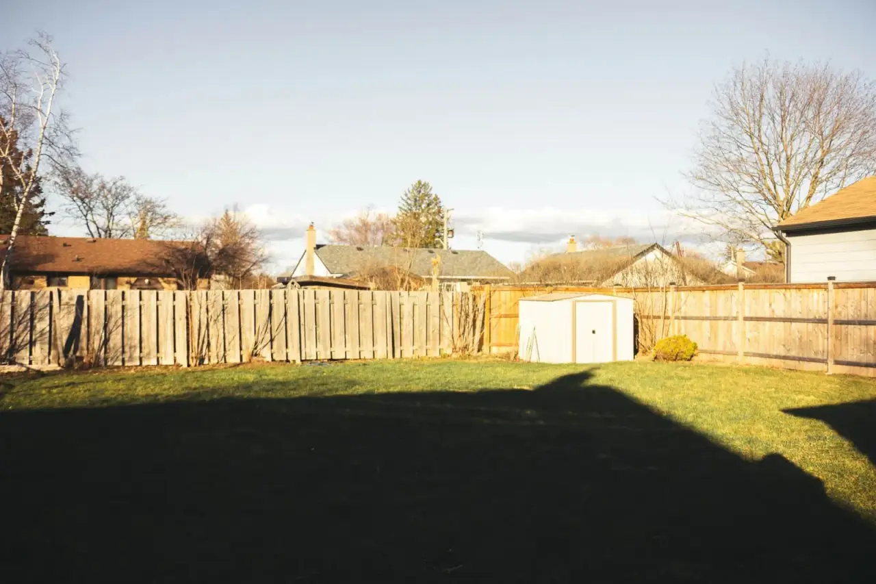 Avant : arrière-cour avec pelouse simple, clôture en bois et abri de jardin, sans aménagement