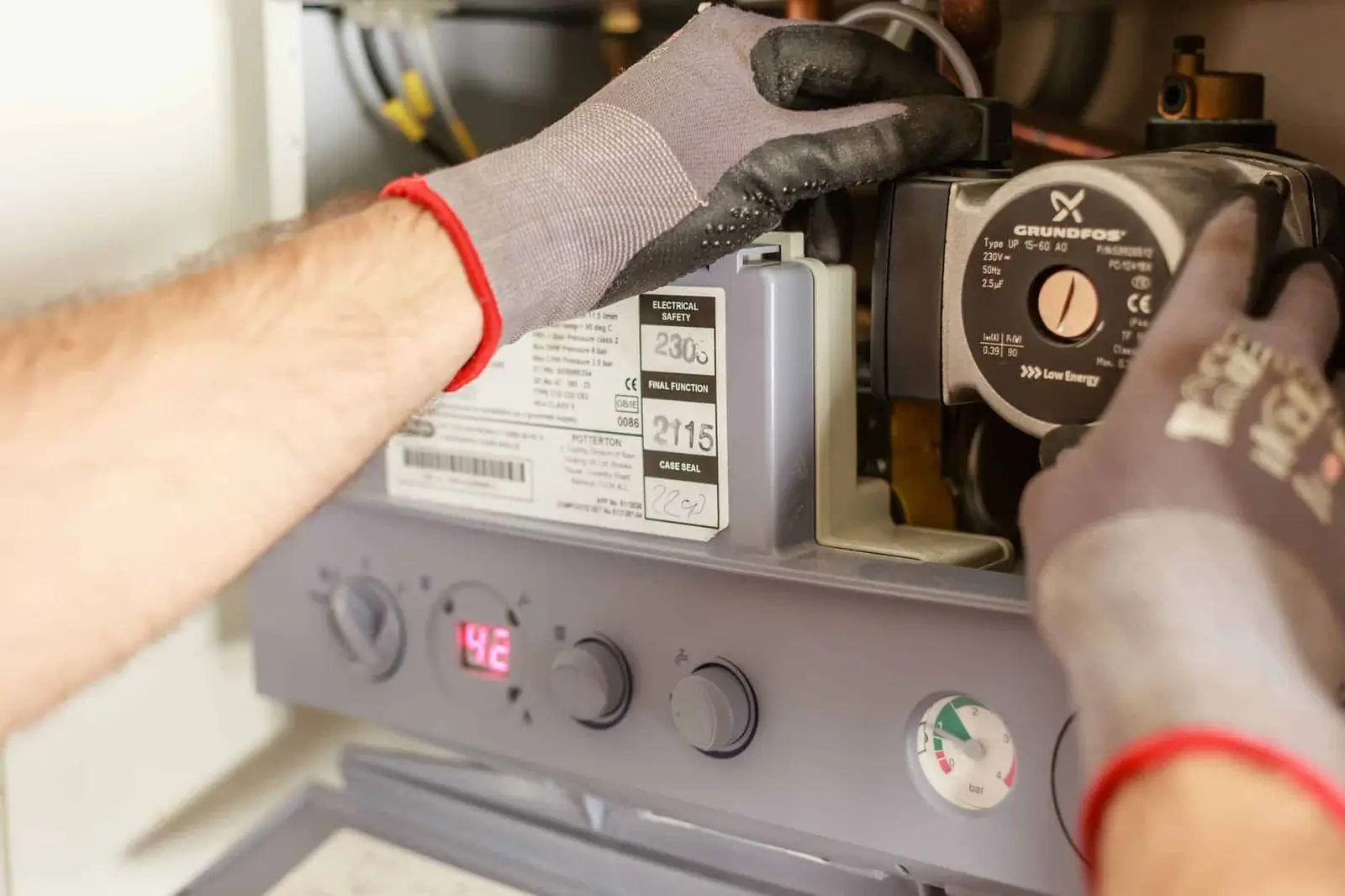 Chauffagiste réglant une installation de chauffage avec ses instruments de mesure