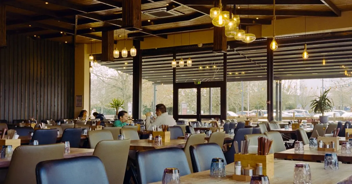 Salle de bistrot chaleureuse avec des clients attablés en soirée